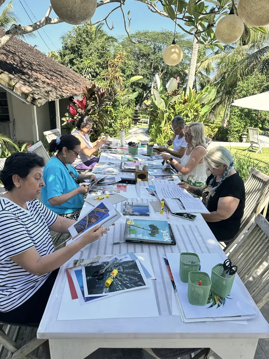 Women at the long table in Bali, choosing images from magazines